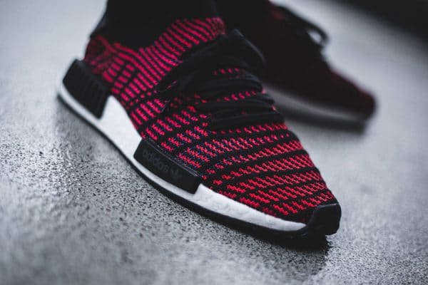 La Adidas NMD_R1 STLT PK 'Black Red' (rayures rouges et noires) on foot (CQ2385)